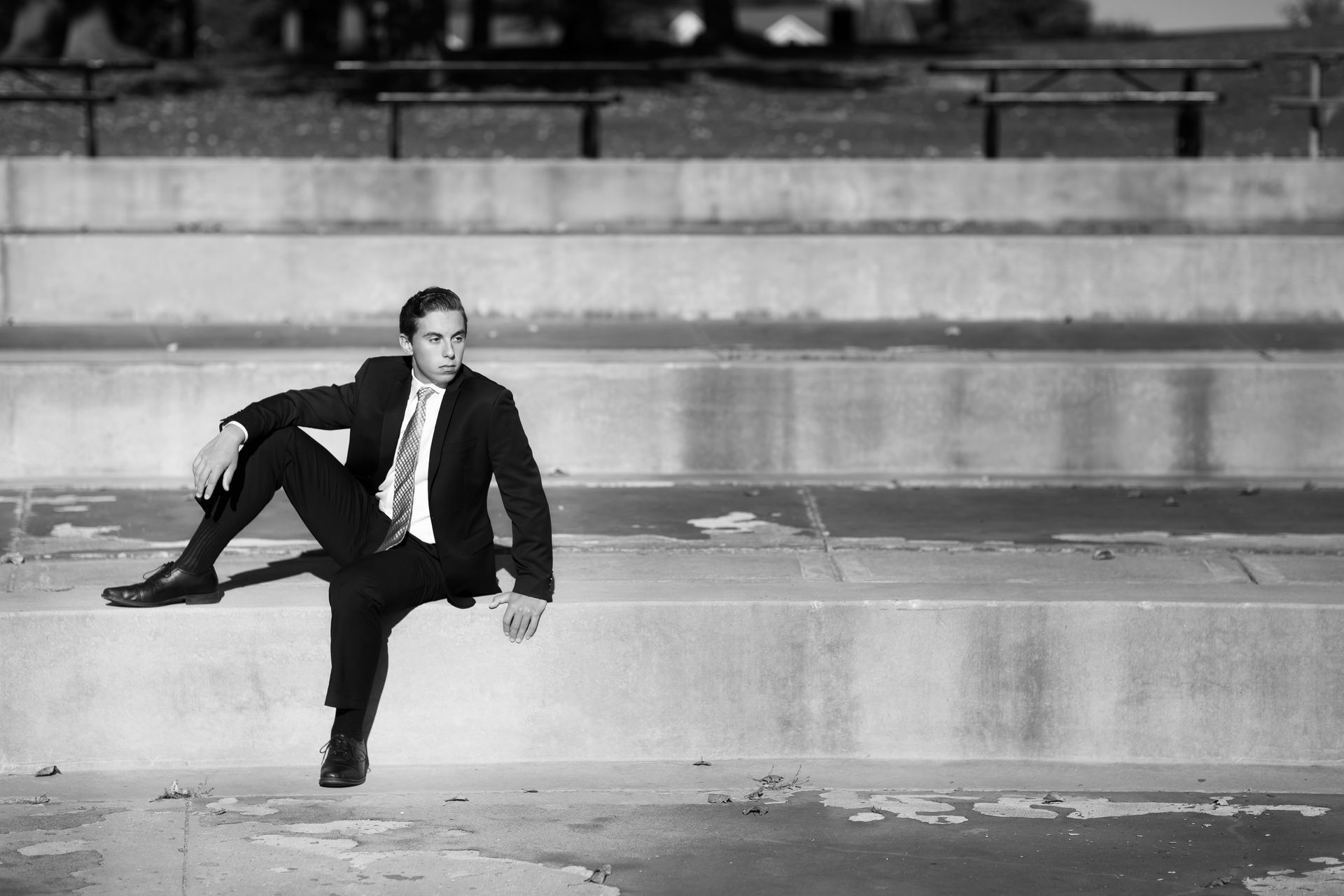 A man in a suit and tie is sitting on a set of stairs.