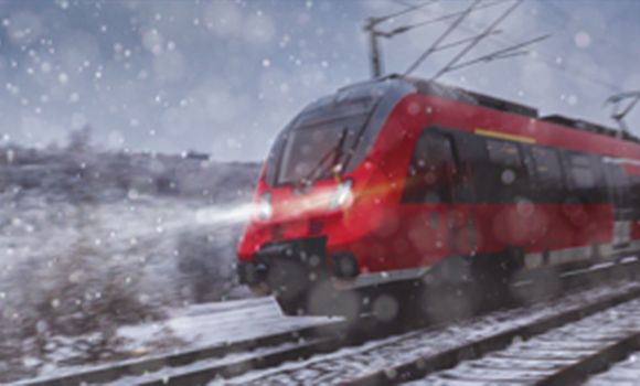 A red train is going down train tracks in the snow.