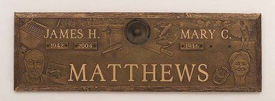 Bronze grave marker for James H. Matthews (1916-2009) and Mary C. Matthews (1916-), with their portraits.