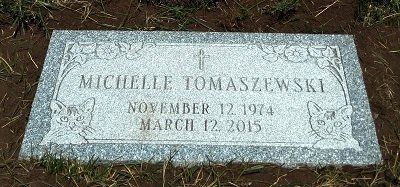 A rectangular headstone engraved with the name Michelle Tomaszewski, dates of birth and death.