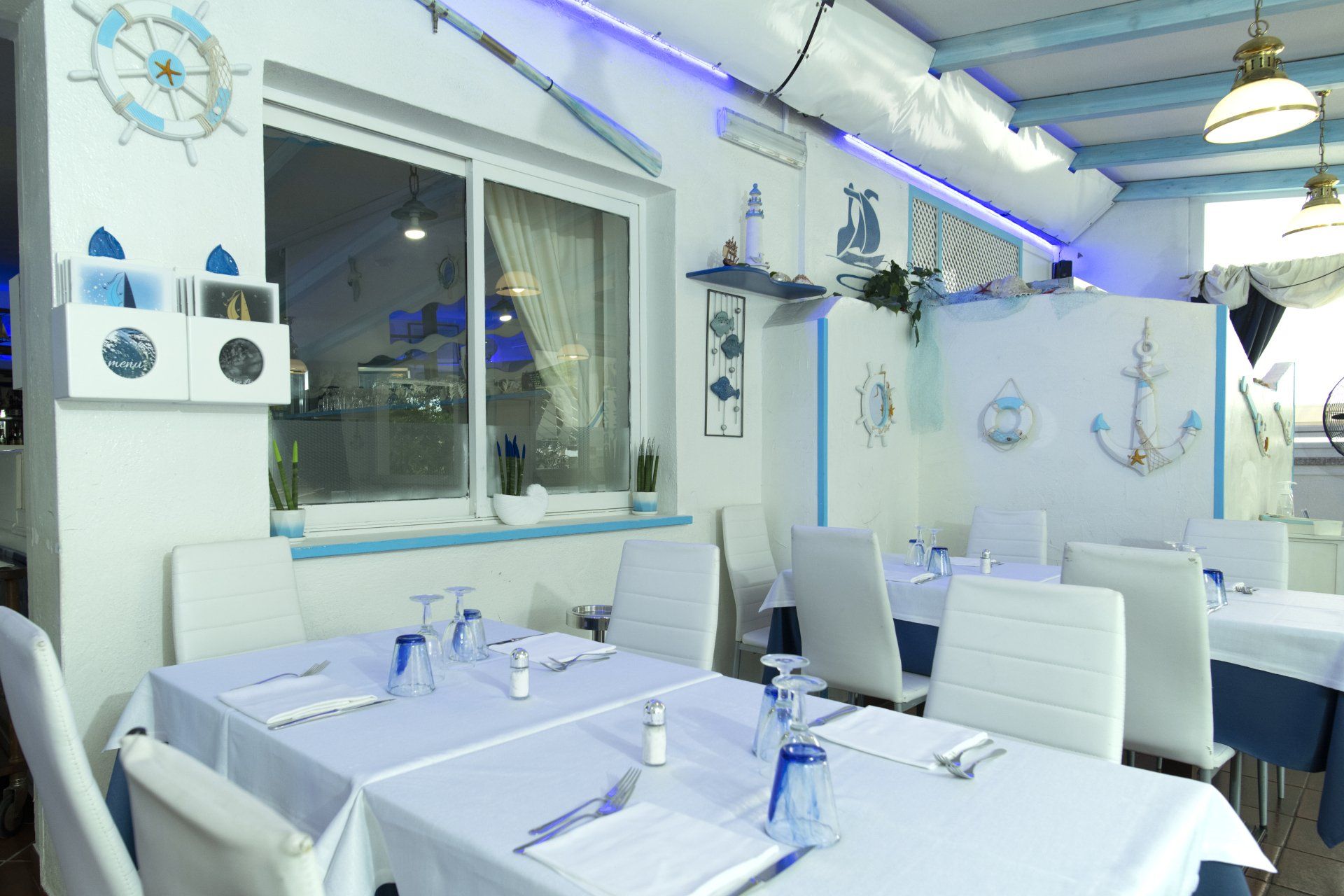 Un ristorante con tavoli e sedie e una finestra