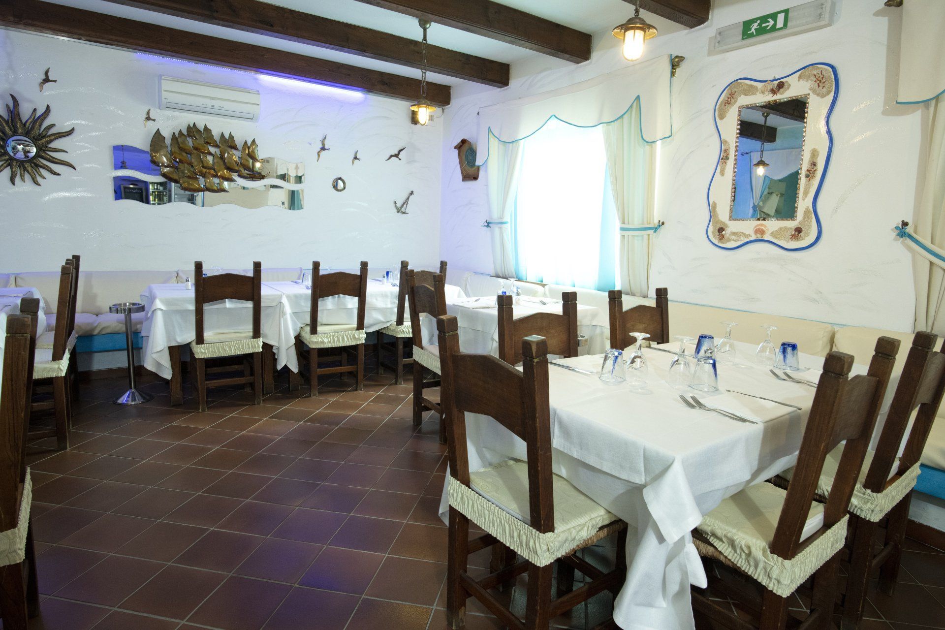 Un ristorante con tavoli e sedie e un cartello con scritto uscita