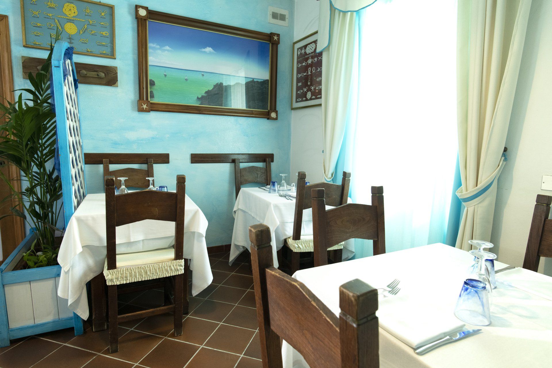 Un ristorante con tavoli e sedie e un quadro sul muro