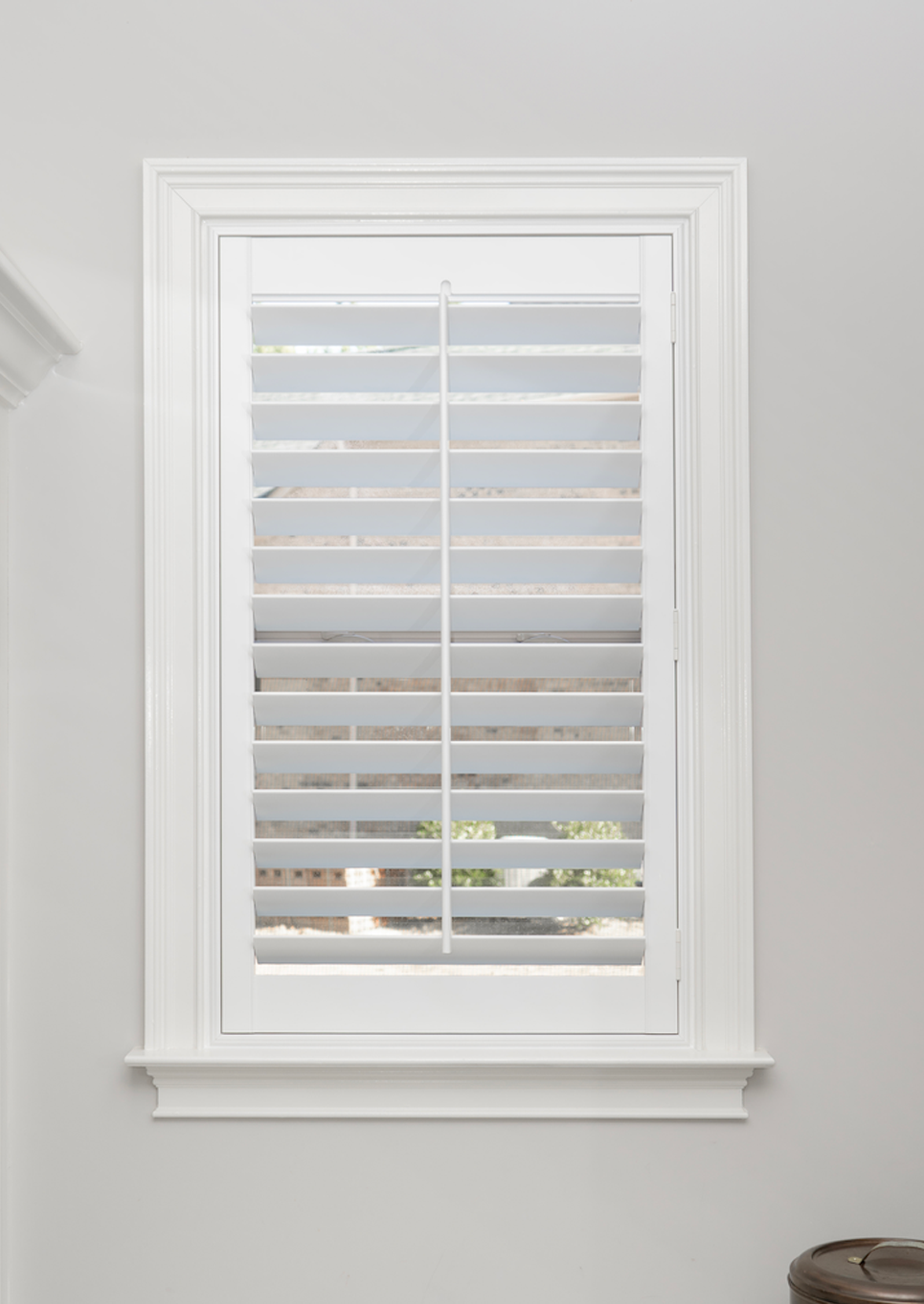 A white 3.5 inch plantation shutter mounted in a mud room window