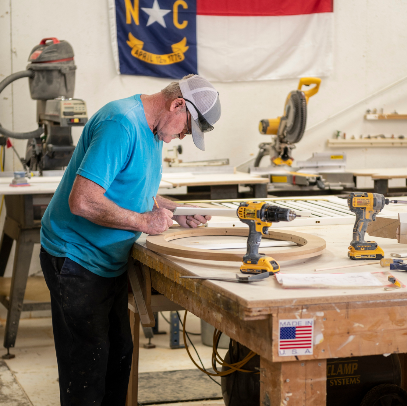 Man standing at woodworking panel building plantation shutters