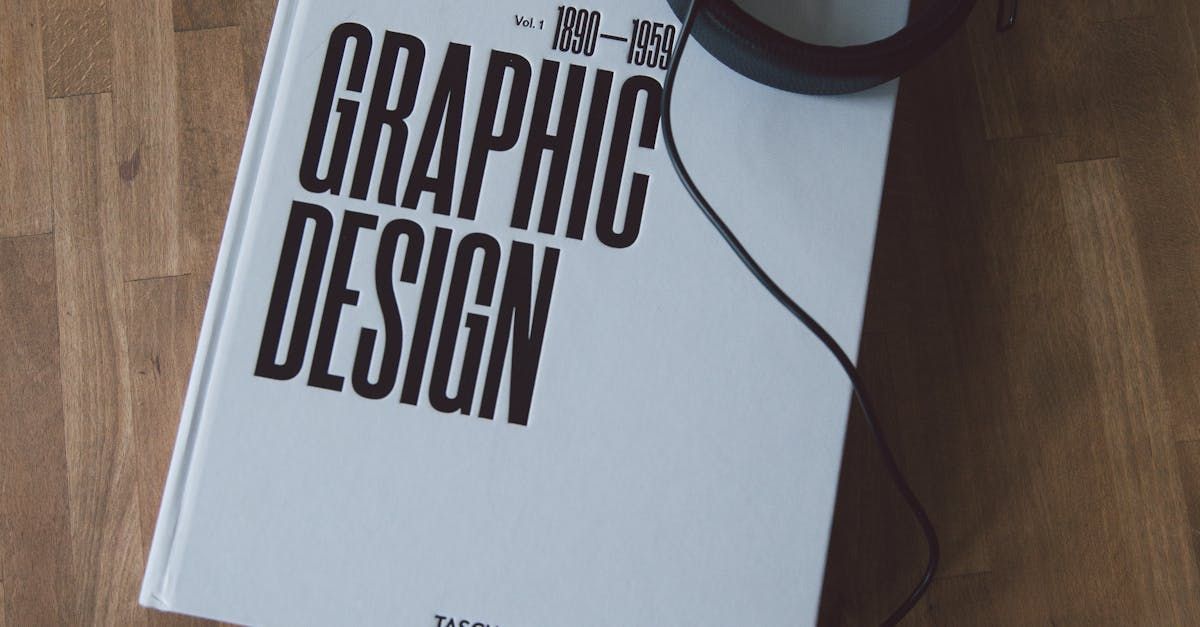 A white book titled graphic design is sitting on a wooden table.