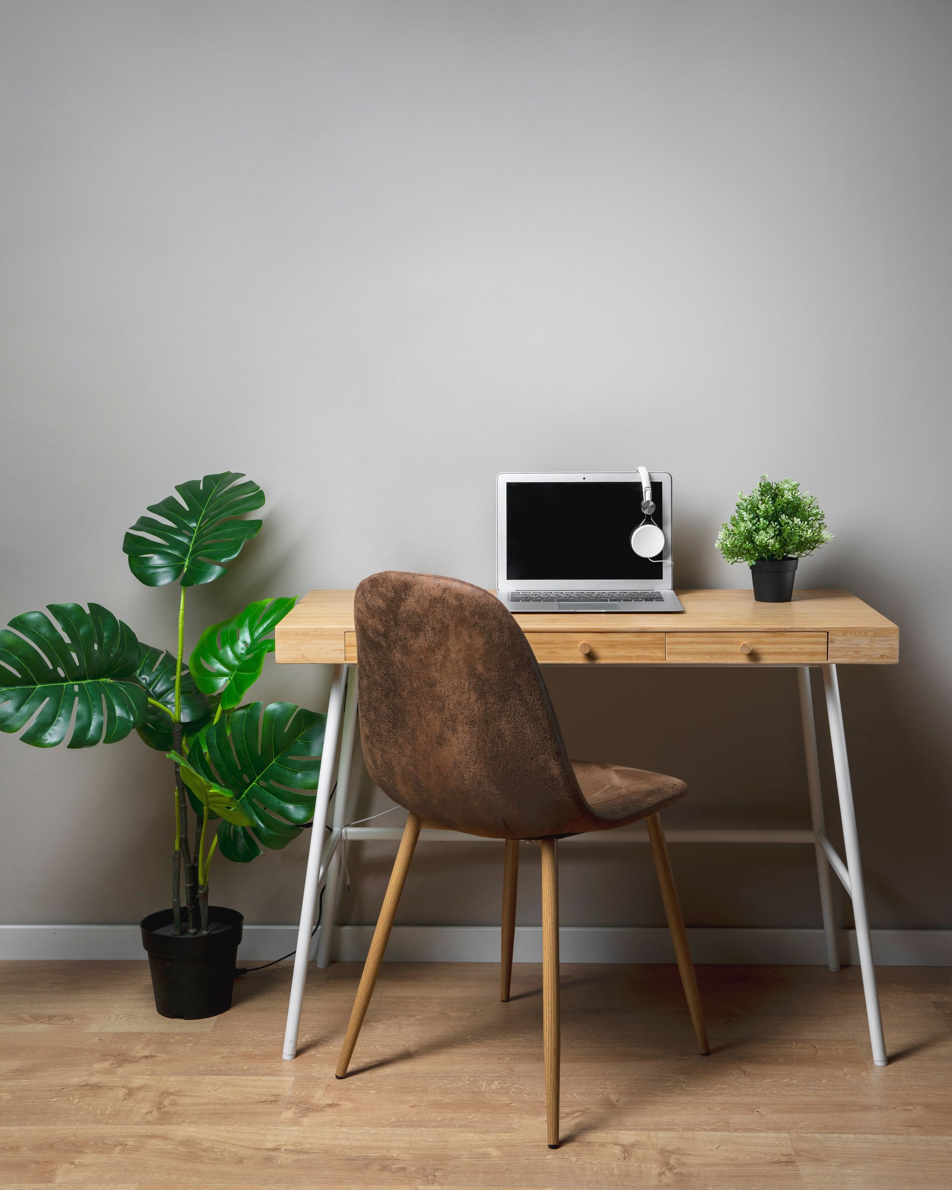Un escritorio de madera con una computadora portátil y una silla.