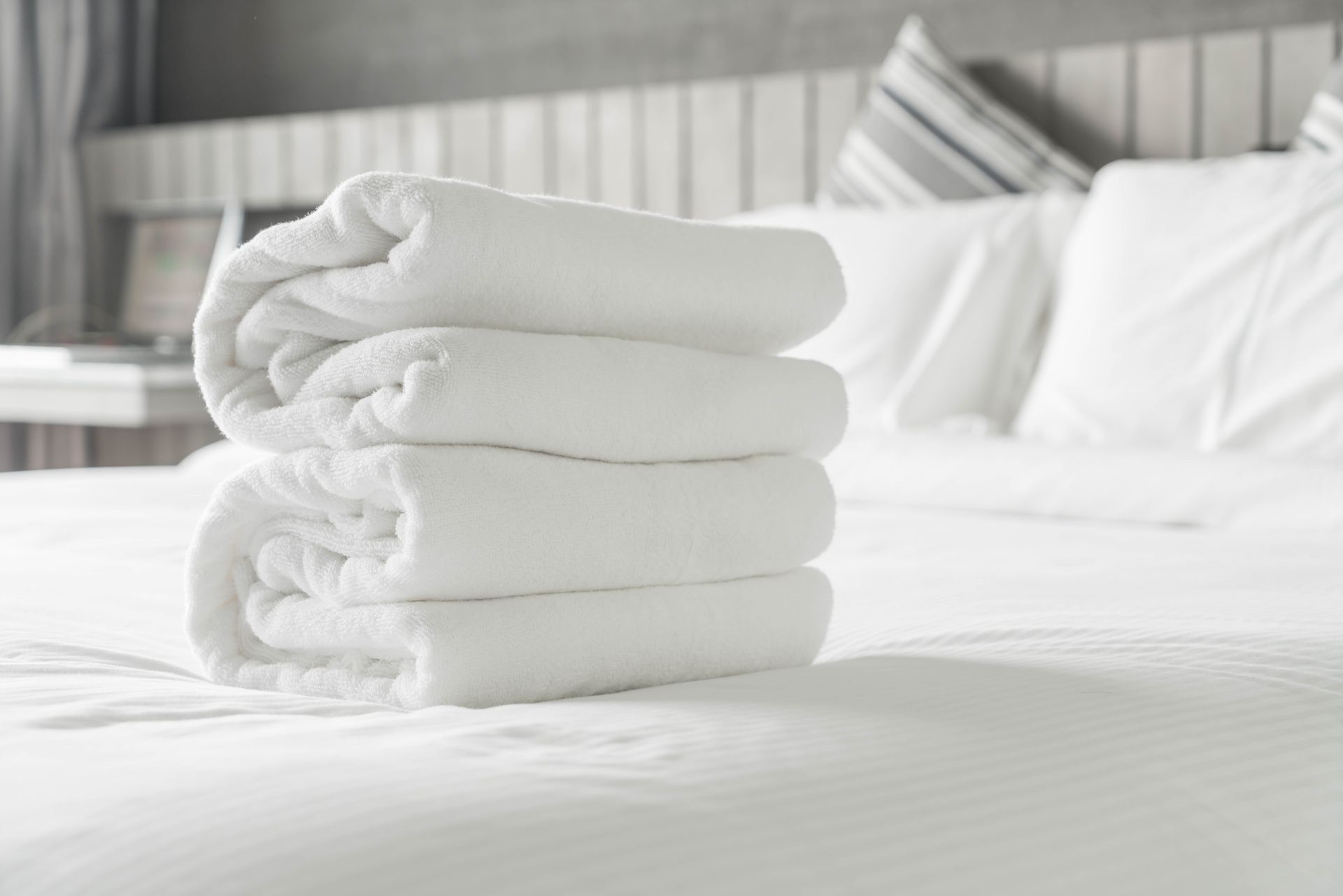 Una pila de toallas blancas encima de una cama.