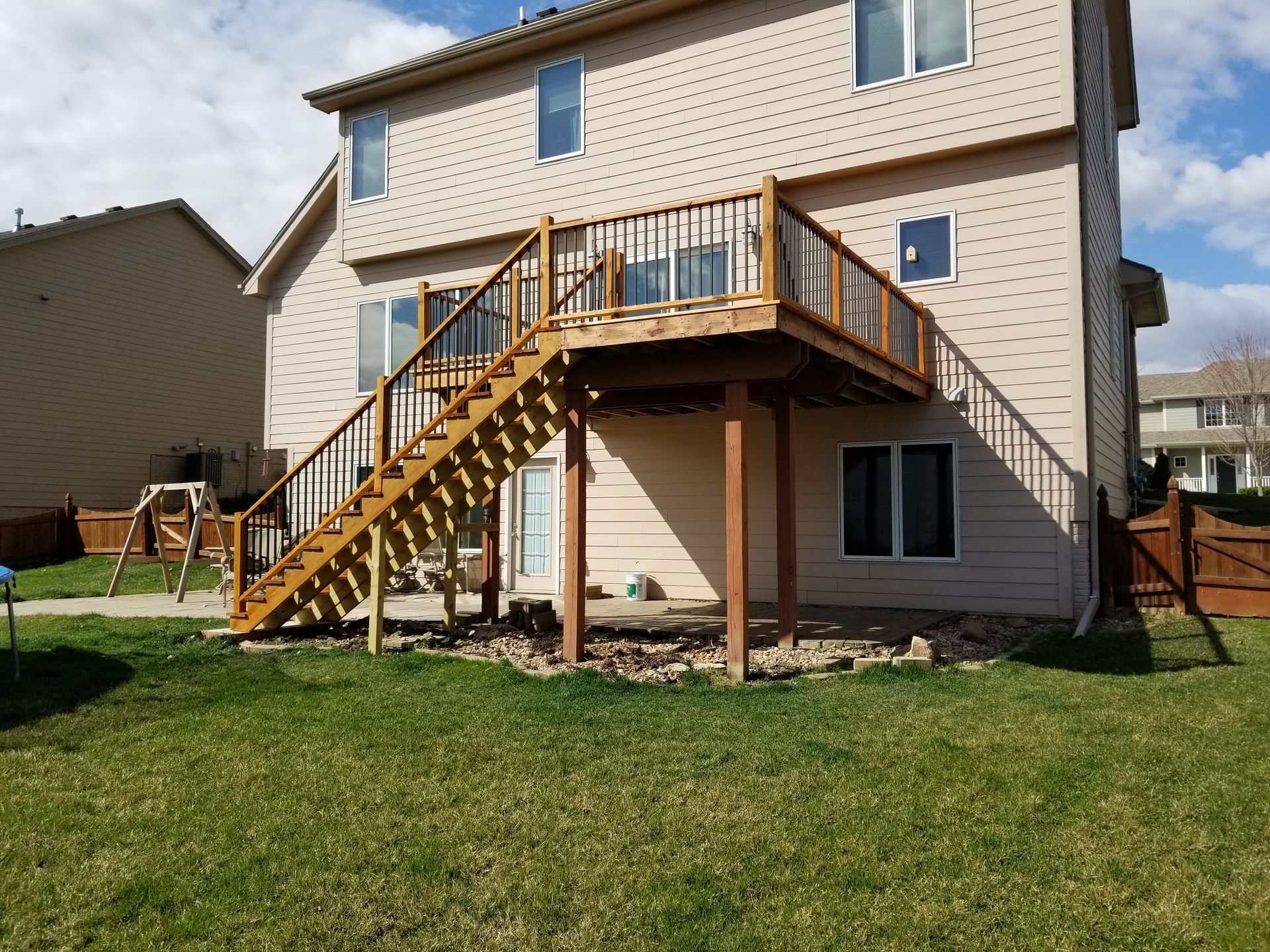 The back of a house with a wooden deck and stairs.