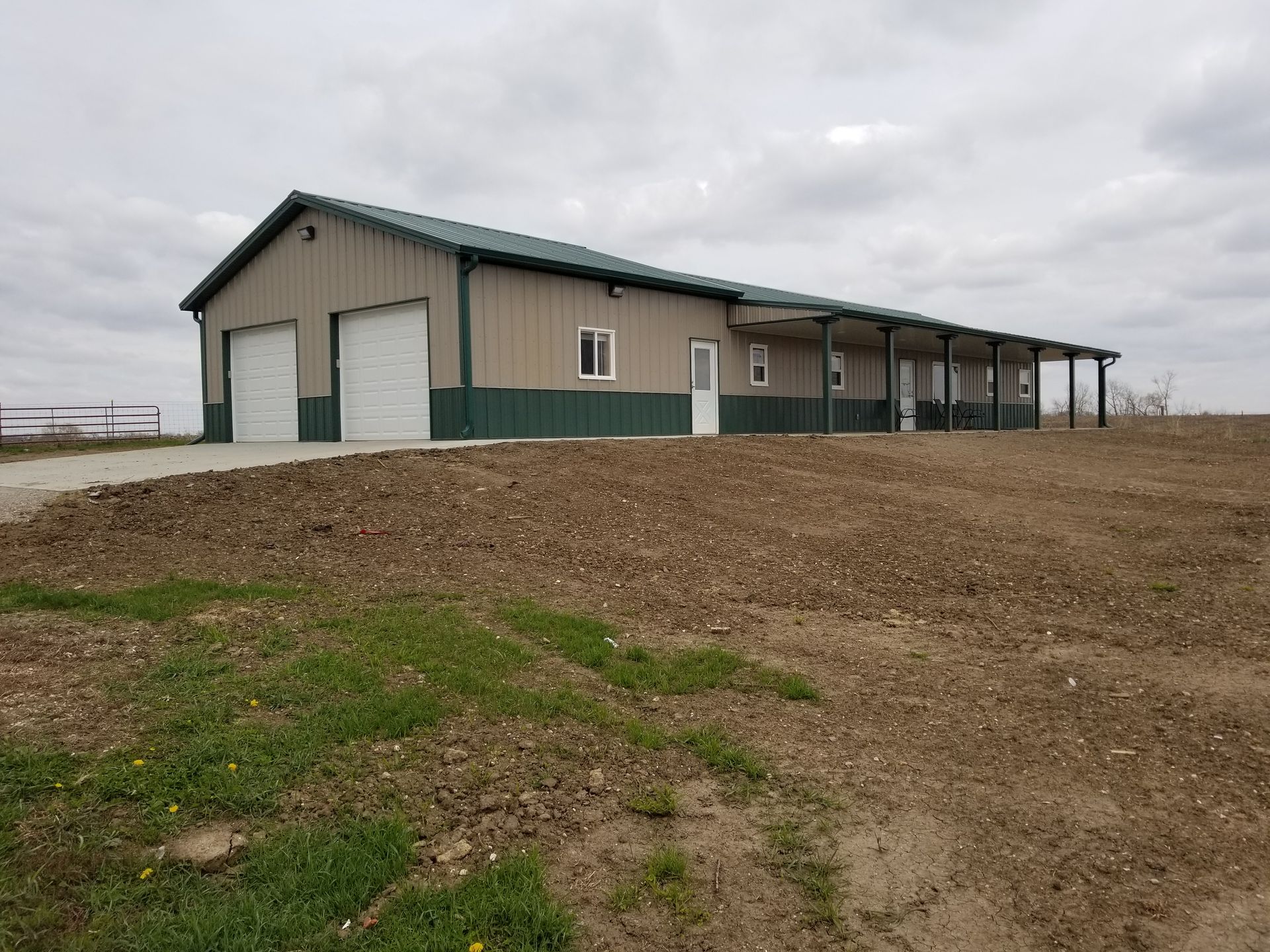 A large building is sitting in the middle of a dirt field.