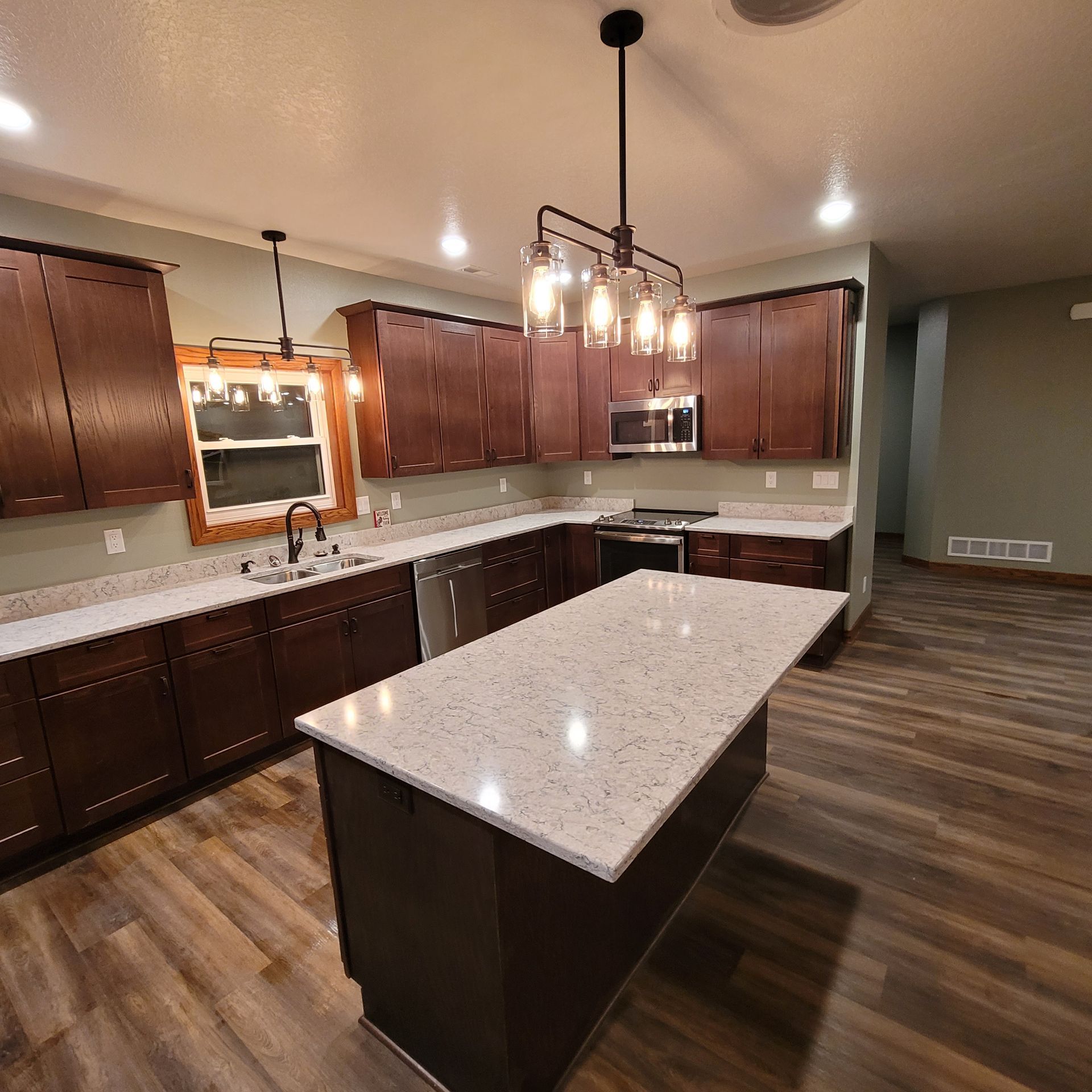 A kitchen with brown cabinets and white counter tops