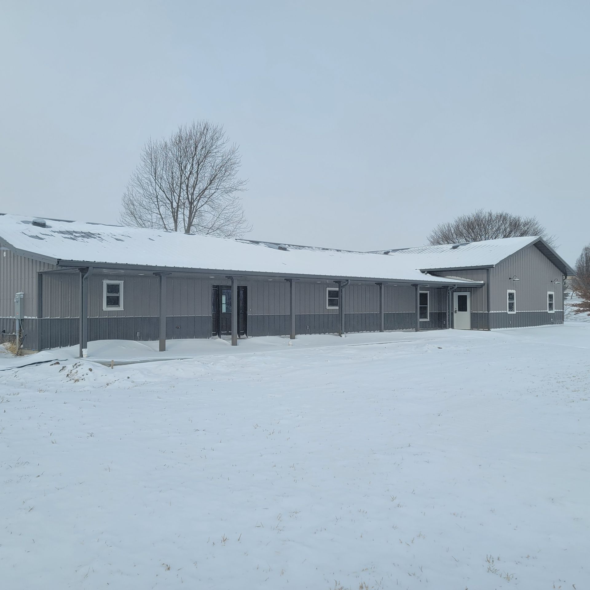 A large gray building is covered in snow
