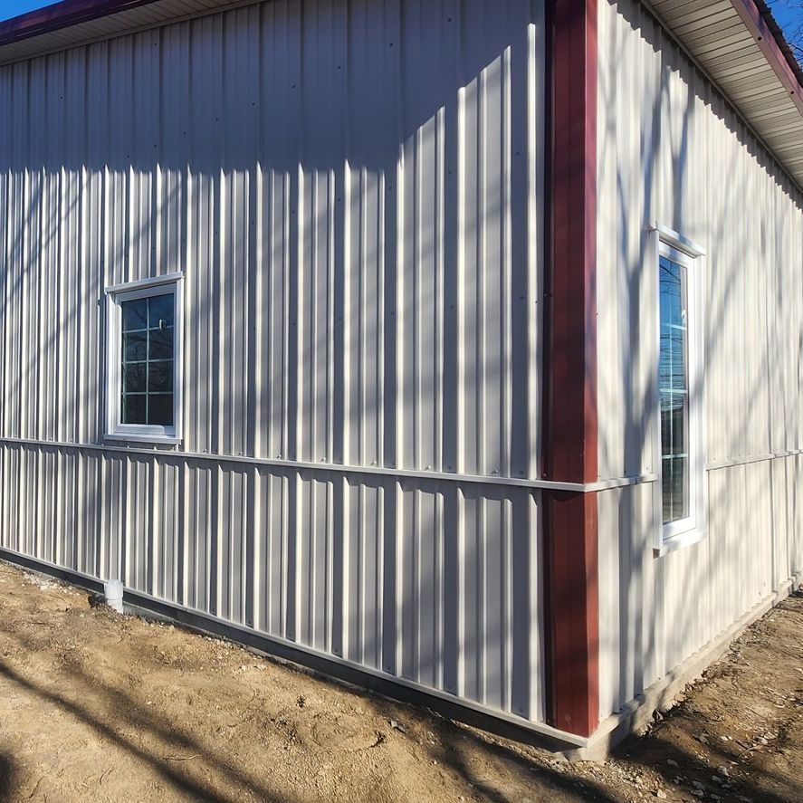 A white building with a red trim and a window