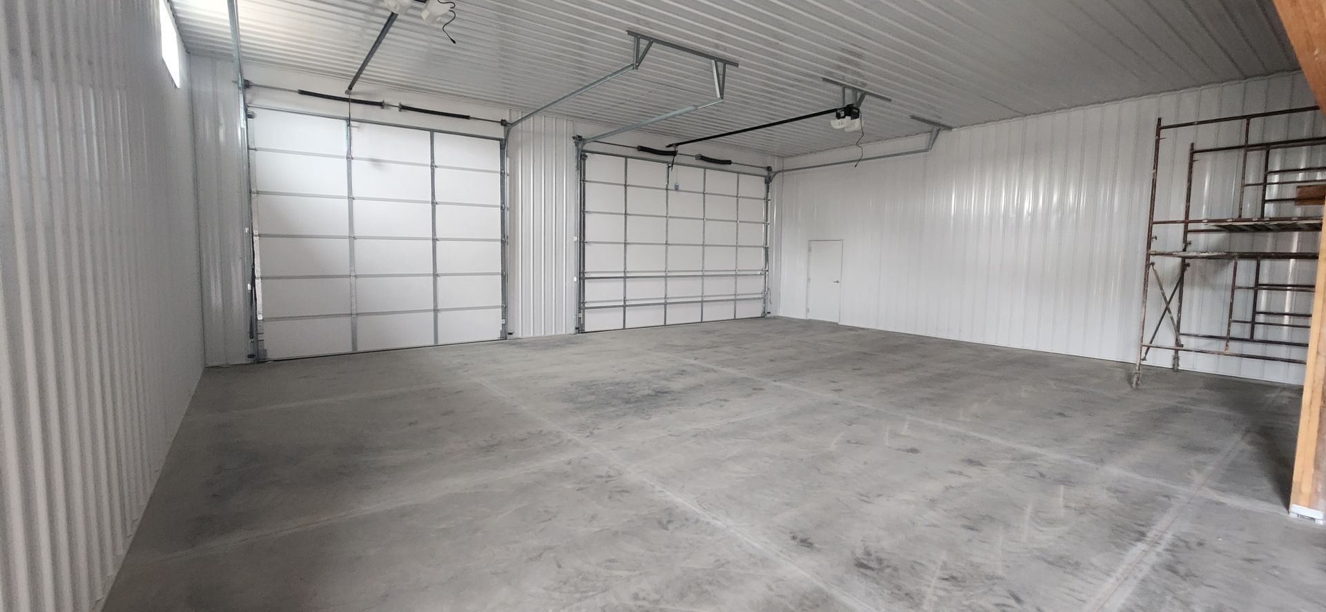 An empty garage with white walls and a concrete floor.