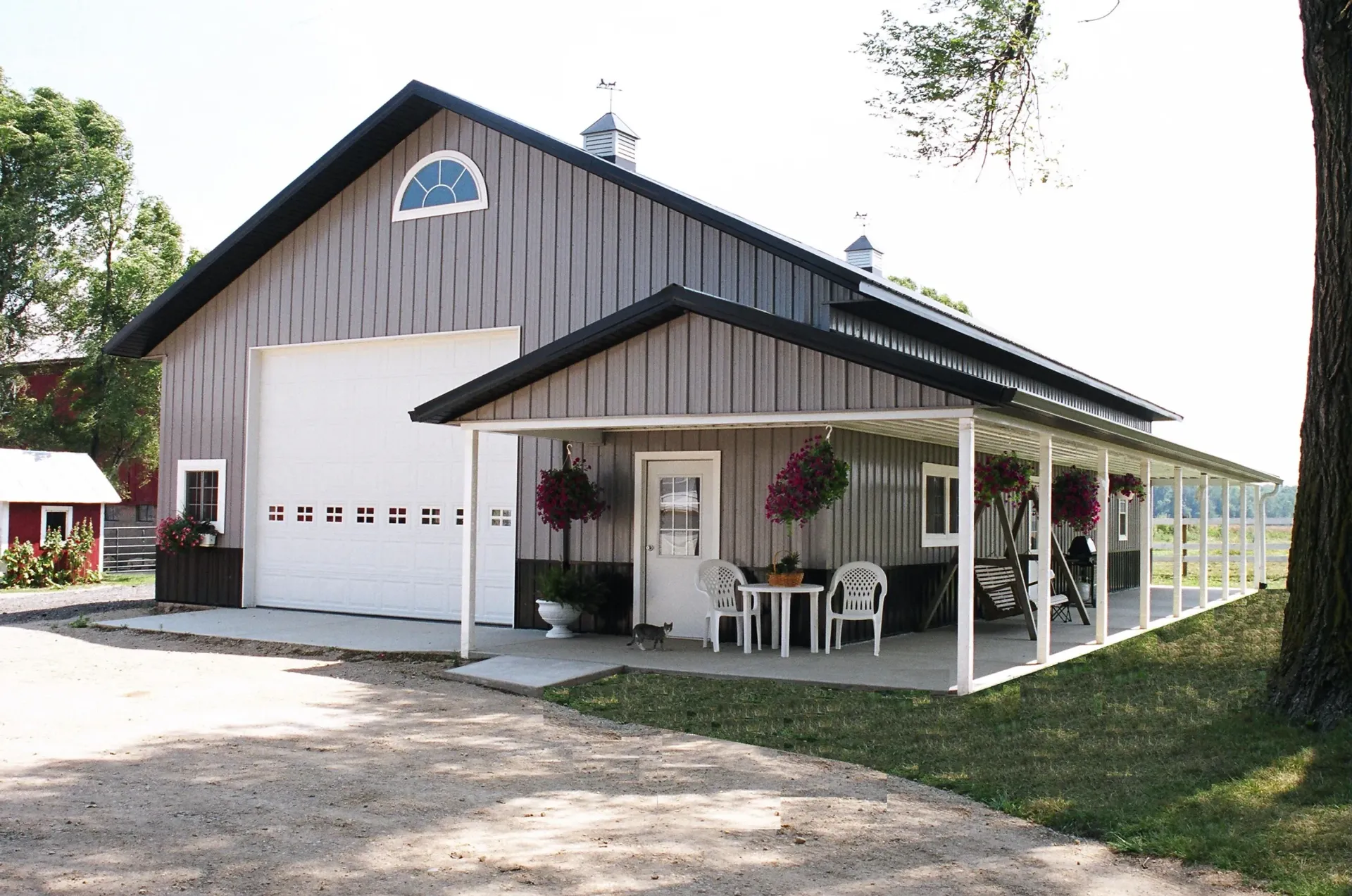A barn with a porch and a table and chairs in front of it