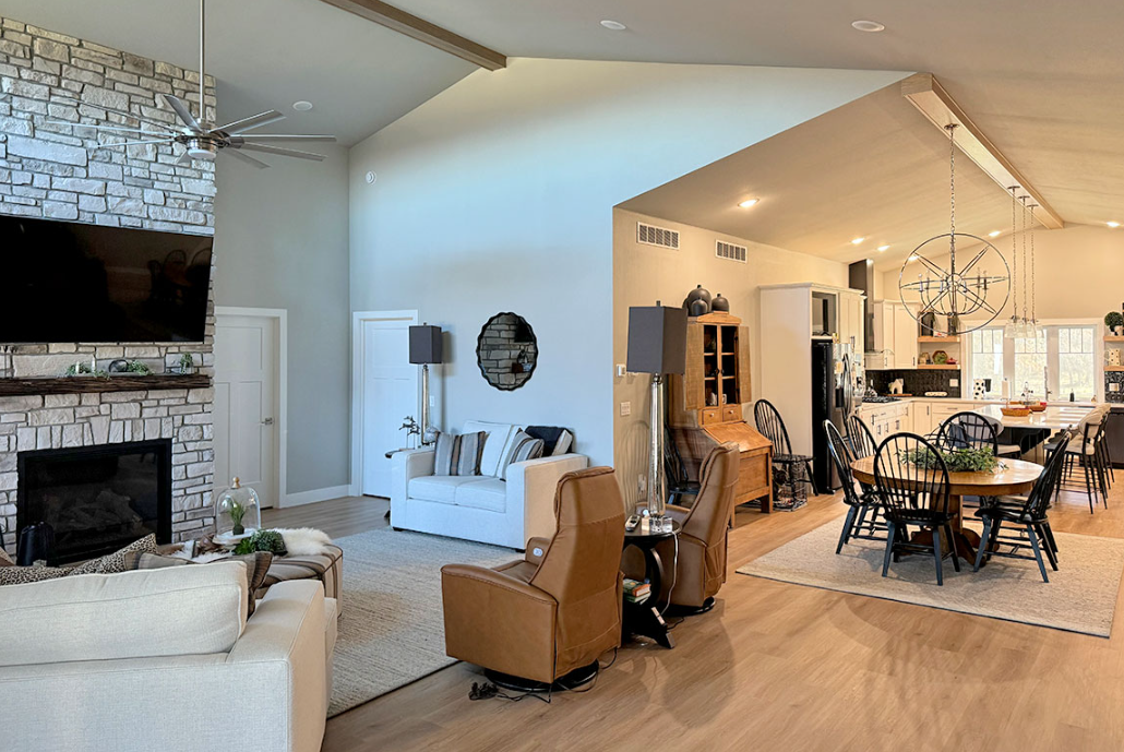 A living room with a fireplace and a dining room with a table and chairs.