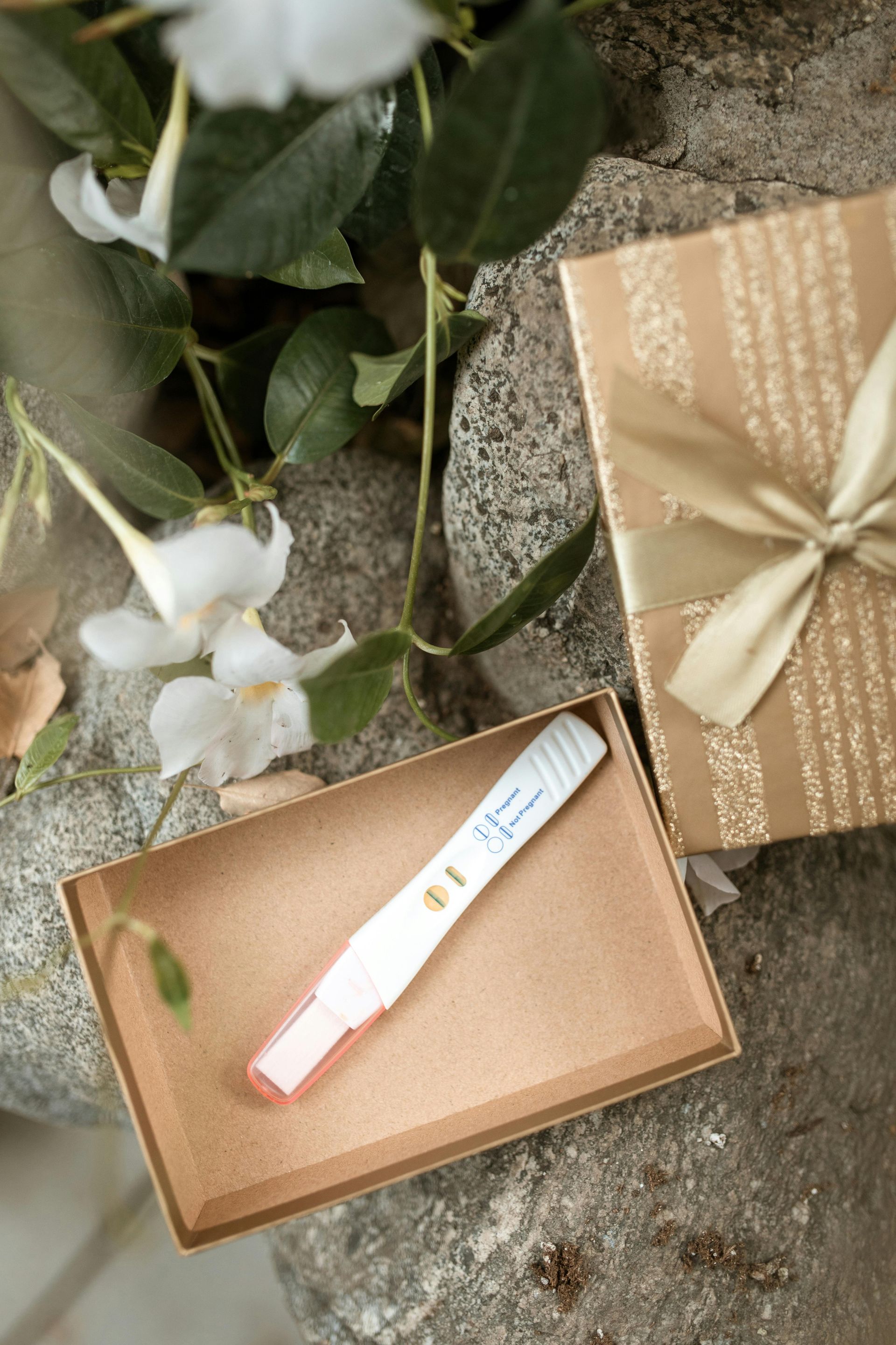 A pregnancy test in a box next to a gift box