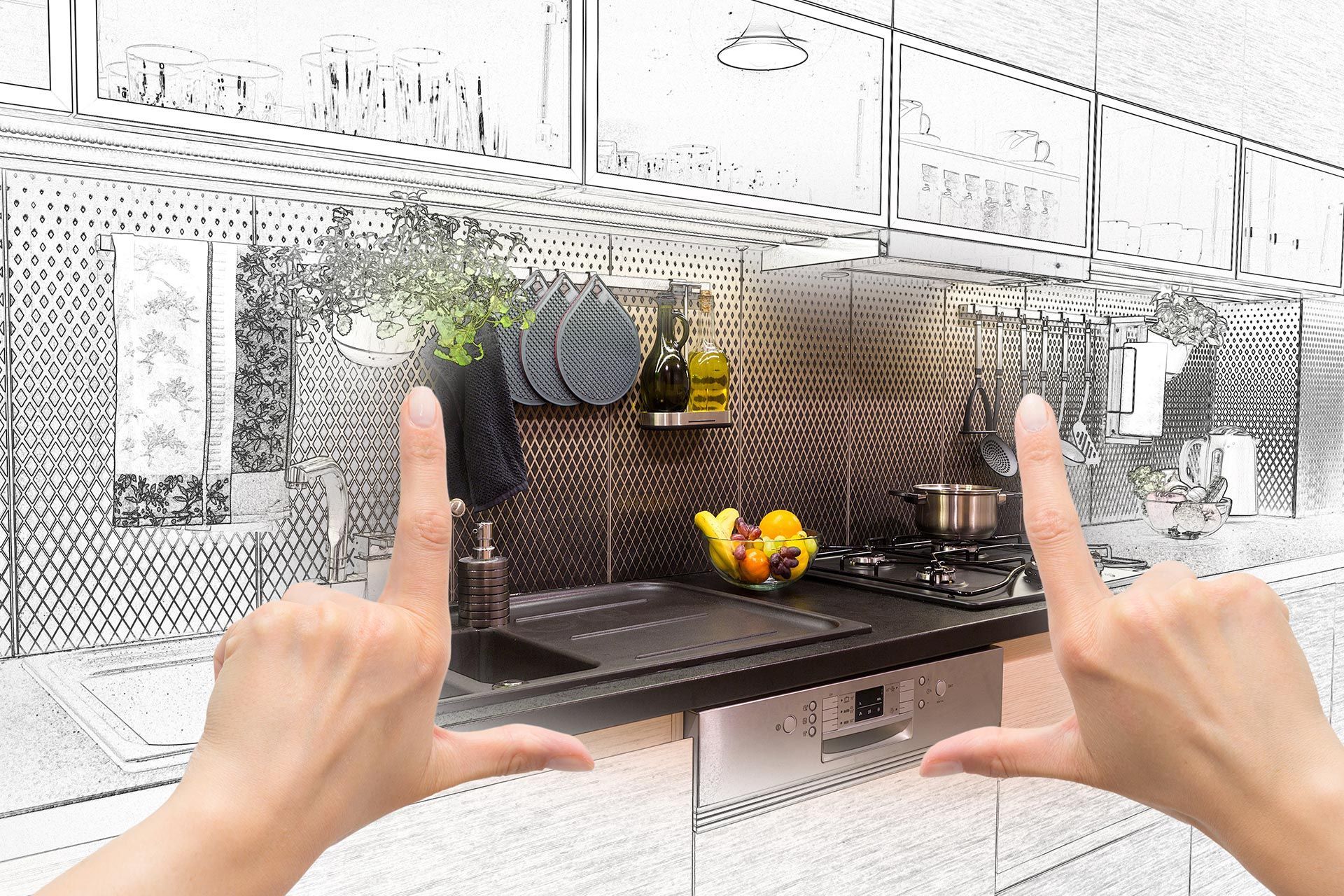 Hands framing a modern kitchen as a sketch transforms into a real space, symbolizing interior design.