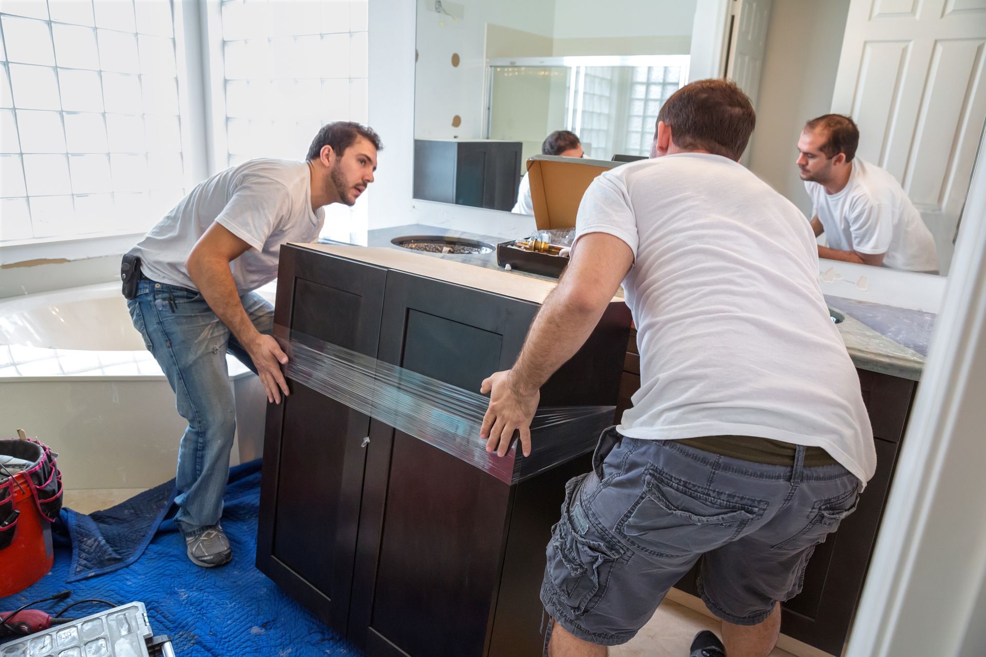 Two men are assembling a bathroom cabinet at Washingtonian Companies, leaders in bathroom remodel in
