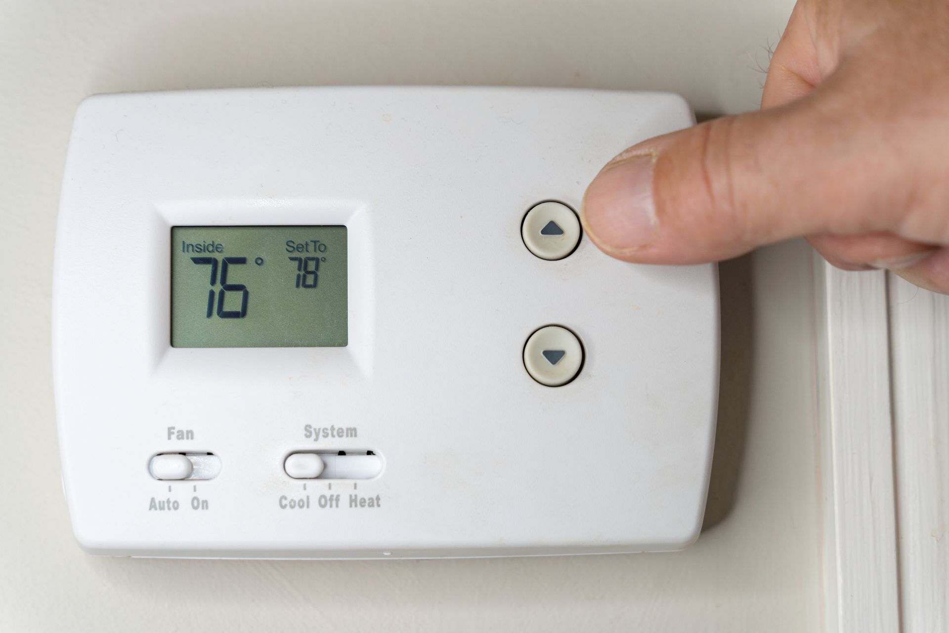 A Person Is Adjusting A Thermostat - Gulfport, MS - McGuffee's Air Conditioning & Heating