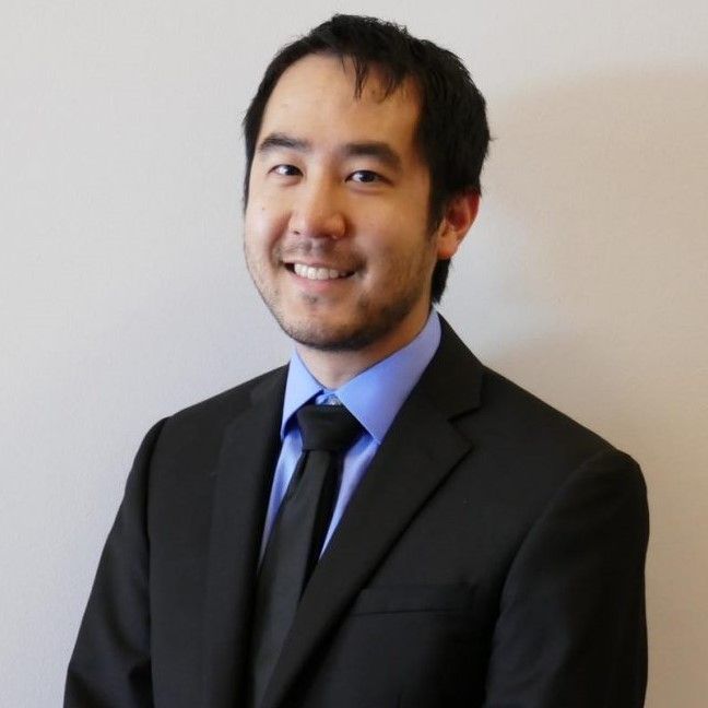 A man in a suit and tie smiles for the camera