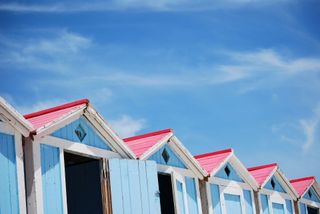 Una fila di colorate cabine sulla spiaggia che si affacciano sull'oceano.