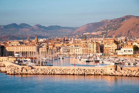 Un porto con barche ormeggiate e una città sullo sfondo.