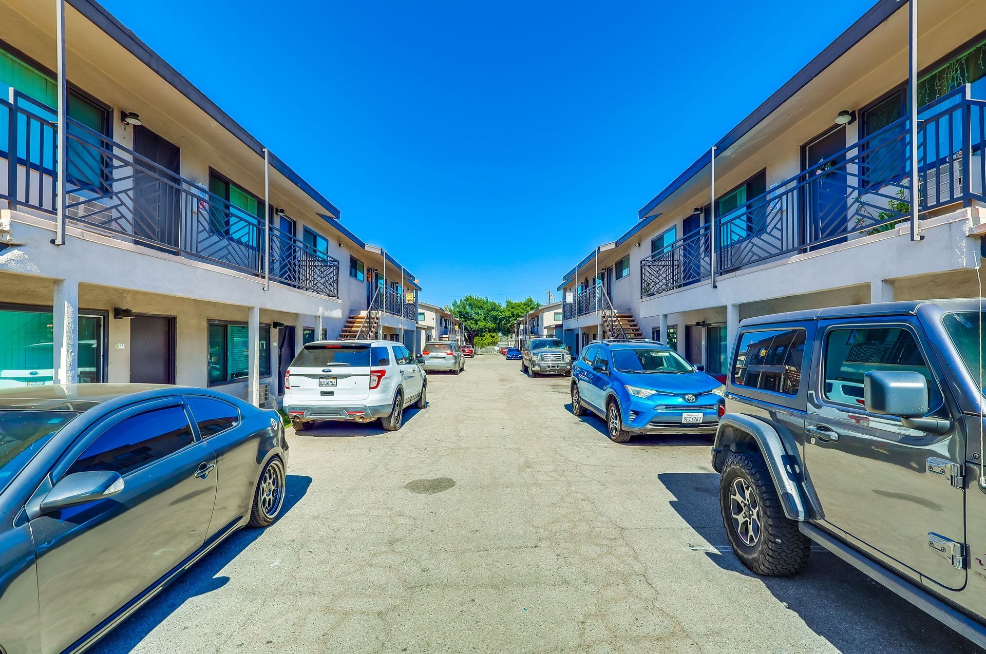 A row of cars are parked in front of a building.