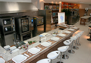 A kitchen with a long counter filled with plates and stools