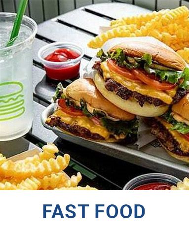 A tray of fast food including hamburgers and french fries on a table.