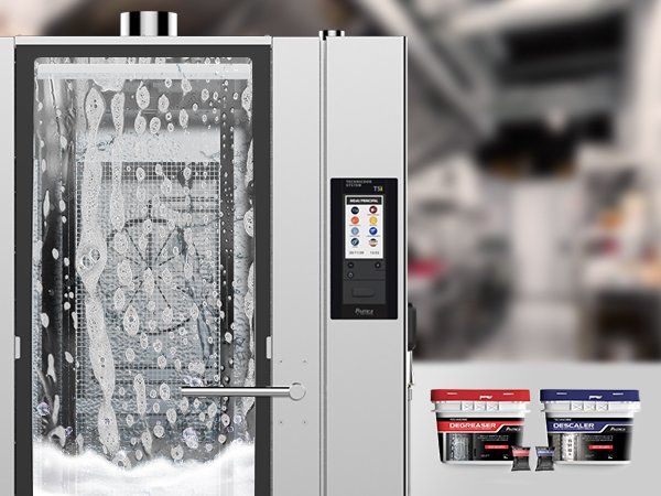 A commercial oven is being cleaned with soap and water in a kitchen.