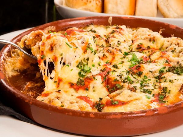 A bowl of food with a fork sticking out of it on a table.