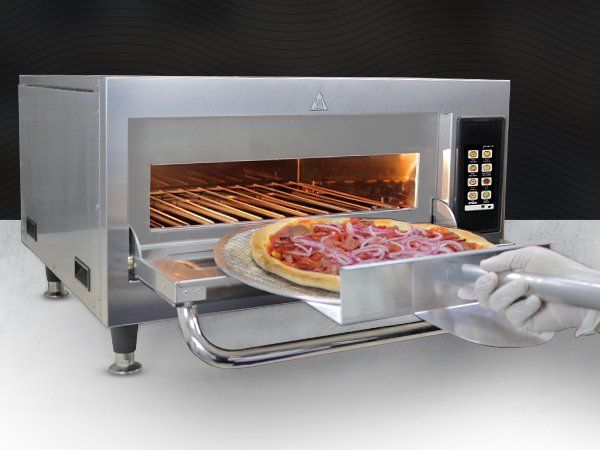 A person is taking a pizza out of an oven