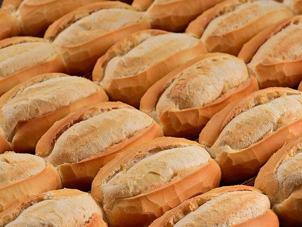 A bunch of rolls of bread are sitting on top of each other on a table.