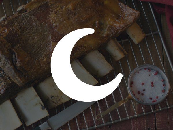 A large piece of meat is sitting on a rack next to a crescent moon