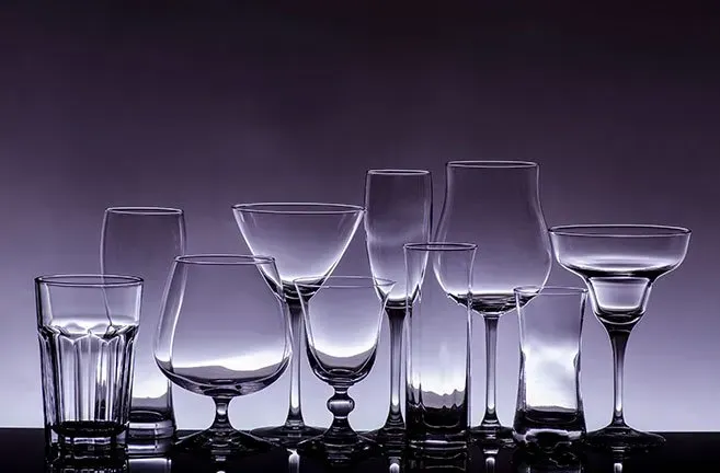 A group of empty wine glasses are lined up on a table.