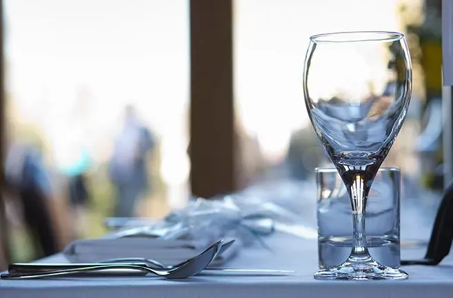 A wine glass and a glass of water are on a table.