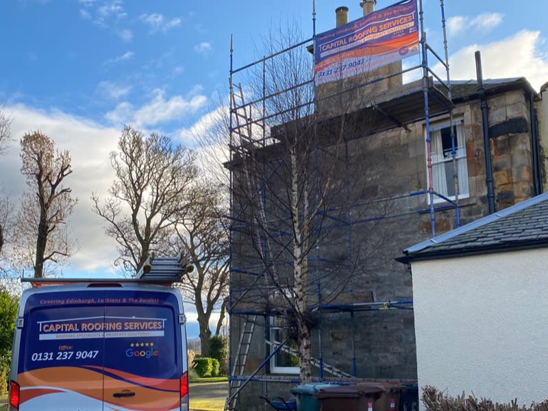 Roof repairs with branded scaffolding outside