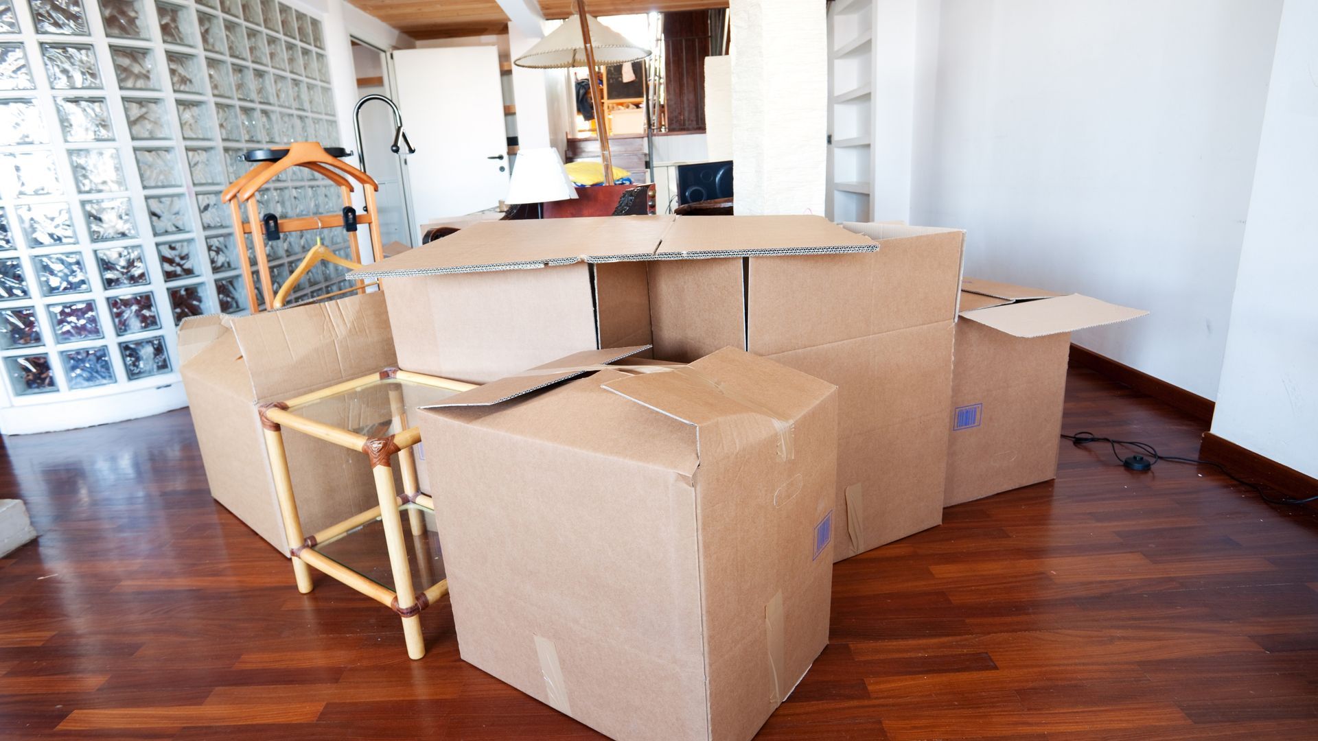 Cardboard boxes arranged to form a fort in a room with hardwood floors.