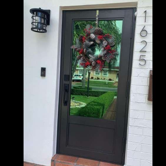 Dark gray door with a wreath, white exterior wall, and house number 1625.
