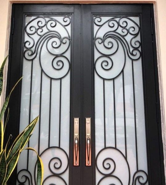 Black double doors with ornate ironwork and frosted glass, bronze handles.