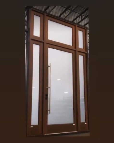 Wooden front door with frosted glass panels and a silver handle.