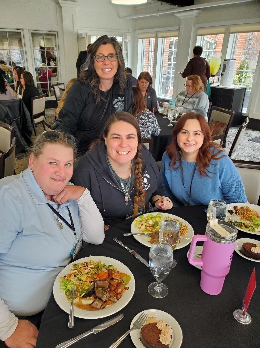 Six people standing in front of a sunrise, facing the horizon.