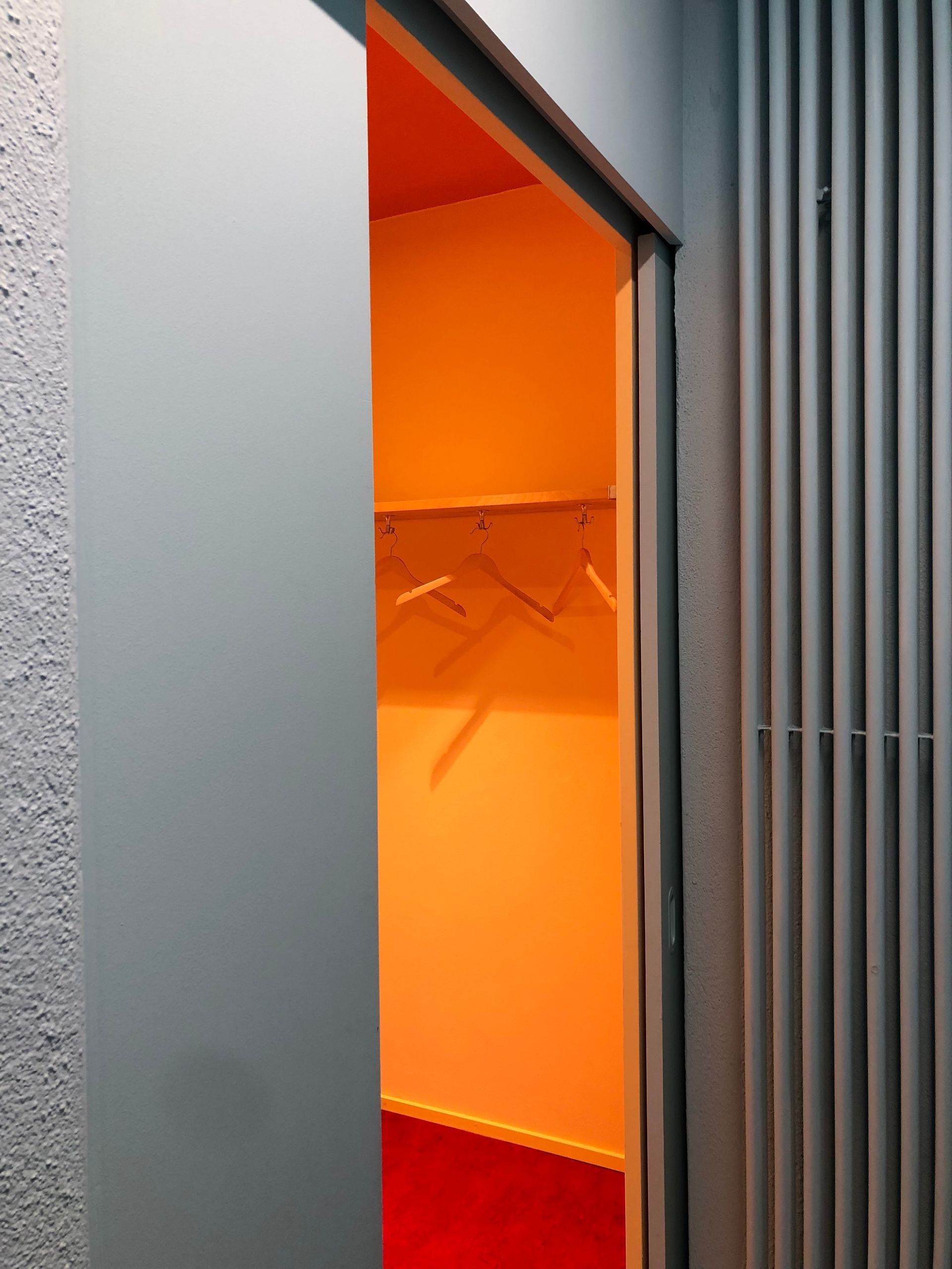 Ein Schrank mit orangefarbenen Wänden und rotem Boden