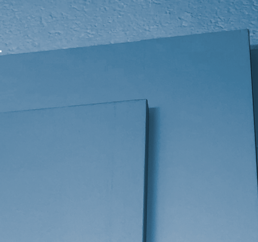 Two blue-painted panels, possibly doors, at a slight angle against a white wall.