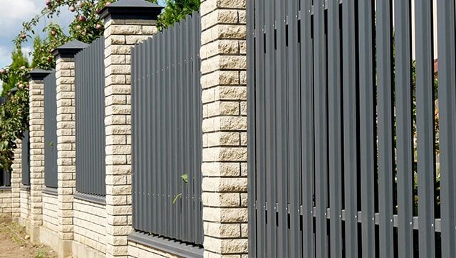 A Fence made of Bricks and Metal is Surrounded by Brick Pillars — Fencing in Port Stephens, NSW
