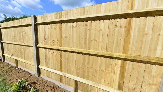 A Wooden Fence is Sitting next to a Building — Fencing in Port Stephens, NSW