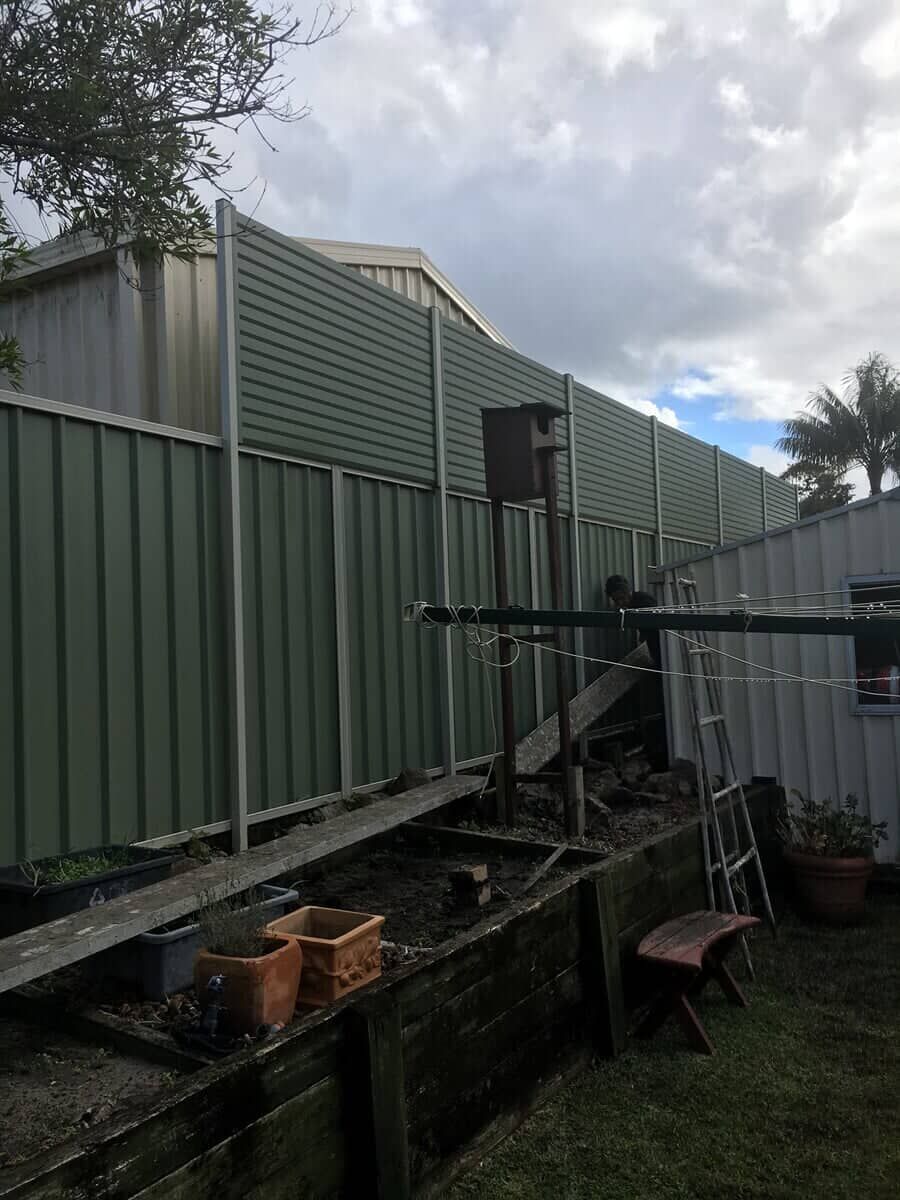 A Green Fence is Being Built in a Backyard — Fencing in Port Stephens, NSW