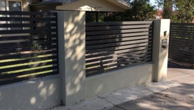 A Black Fence is Surrounding a House on a Sidewalk — Fencing in Port Stephens, NSW
