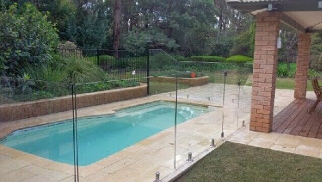 A Large Swimming Pool Surrounded by a Glass Fence in a Backyard — Fencing in Port Stephens, NSW